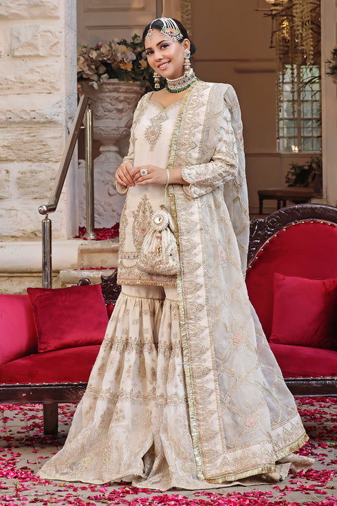 Naqshi Zonar off‑white organza short shirt heavily embellished with naaḳshi-dabka, mirror work, scalloped hem and tassels, paired with matching gipsy gharara and ornate dupatta.